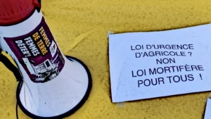 mégaphone et pancarte "loi d'urgence agricole ? Non ! Loi mortifère pour tous"